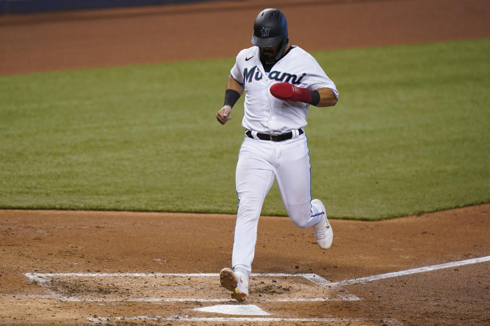 Miami Marlins' Jorge Alfaro scores on a single by Starling Marte during the third inning of the first game of a baseball doubleheader against the Philadelphia Phillies, Sunday, Sept. 13, 2020, in Miami. (AP Photo/Wilfredo Lee)