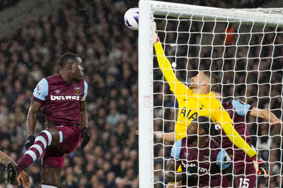 Tottenham's goalkeeper Guglielmo Vicario, right, makes a save in front of West Ham's Kurt Zouma during the English Premier League soccer match between West Ham and Tottenham, at the London stadium in London, Tuesday, April 2, 2024. (AP Photo/Kirsty Wigglesworth)
