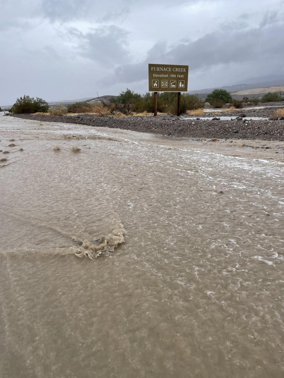 Muddy water covers CA-190 near Furnace Creek. (NPS photo)