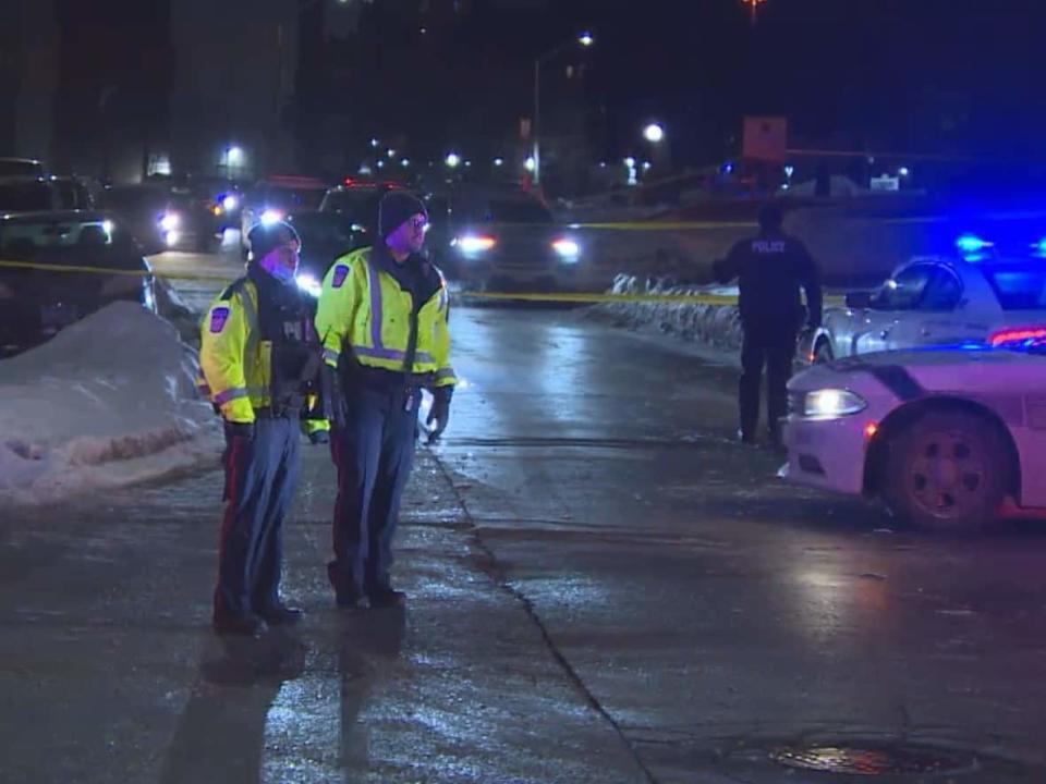 Peel police stand near the scene where Mohamed Ahmed was fatally stabbed on Tuesday. (CBC - image credit)