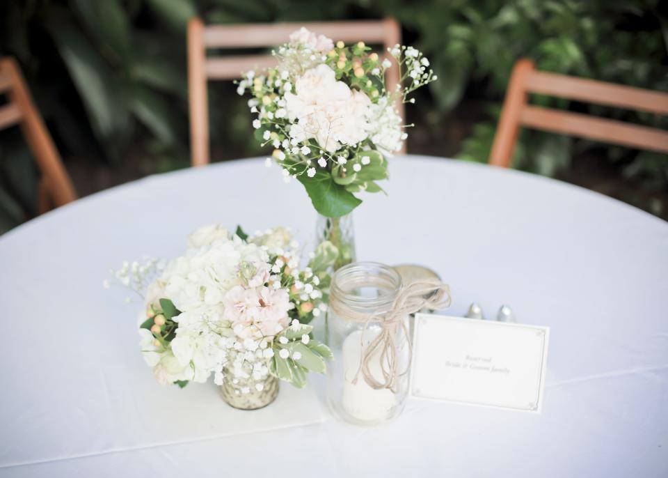 white flowers in the center of a table at a wedding - ceremony centerpiece wedding flowers decorations