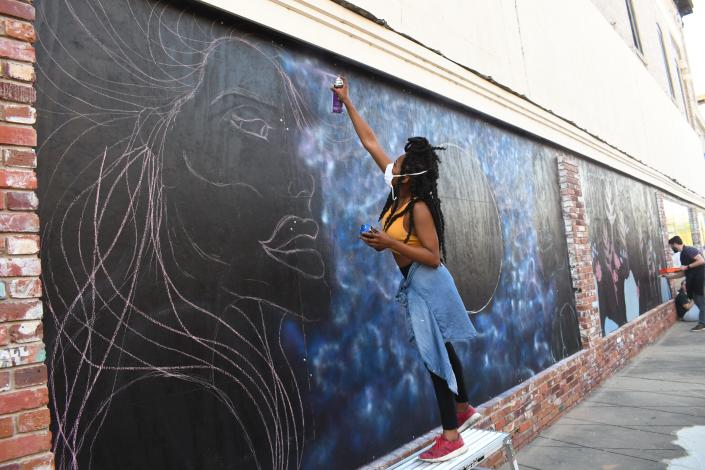 Takiya Jones&nbsp;of Alexandria is&nbsp;making a&nbsp;statement with the first mural she has ever painted. &quot;This piece is called 'Unity,'&quot; said the 26-year-old. She and other artists were painting live during Alex RiverFete held Friday and Saturday in downtown Alexandria.