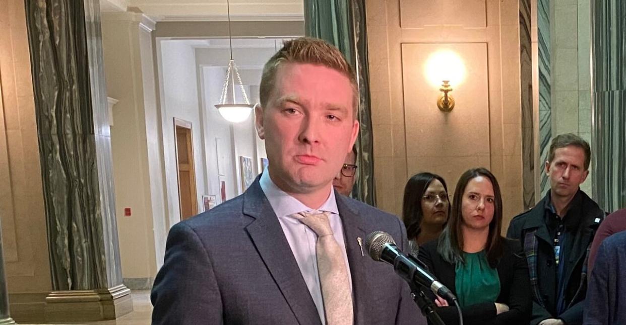 Education Minister Jeremy Cockrill, left, speaks at the Legislature in Regina while Saskatchewan Teachers' Federation president Samantha Becotte (in green) looks on. (Adam Hunter/CBC - image credit)