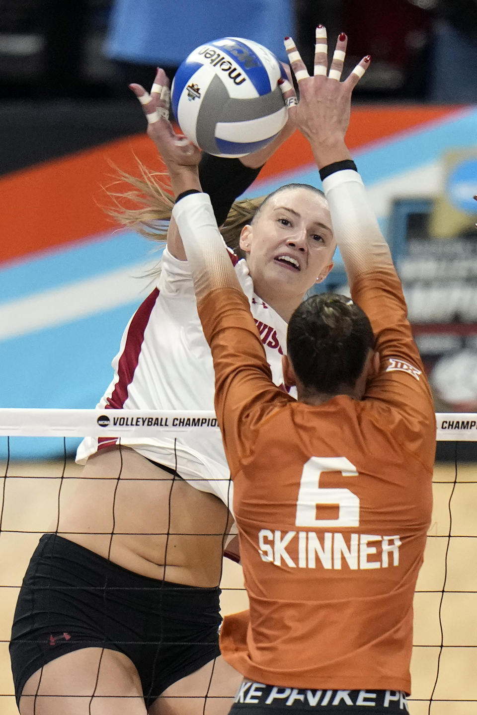 Wisconsin's Anna Smrek (14) scores past Texas's Madisen Skinner (6) during a semifinal match in the NCAA Division I women's college volleyball tournament Thursday, Dec. 14, 2023, in Tampa, Fla. (AP Photo/Chris O'Meara)