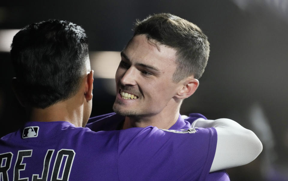 Colorado Rockies' Alan Trejo, left, hugs Brenton Doyle as he returns to the dugout after hitting a two-run home run against Arizona Diamondbacks relief pitcher Luis Frias in the seventh inning of a baseball game Tuesday, Aug. 15, 2023, in Denver. (AP Photo/David Zalubowski)