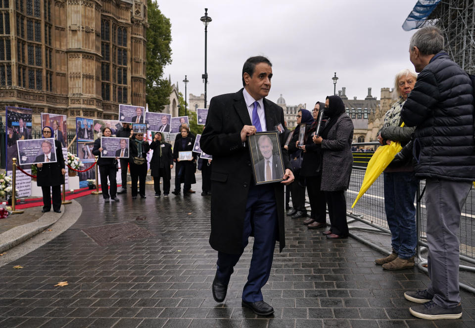 Members of the Anglo-Iranian communities and supporters of the National Council of Resistance of Iran hold a memorial service for British MP David Amess outside the Houses of Parliament in London, Monday, Oct. 18, 2021. British lawmaker David Amess was killed on Friday during a meeting with constituents at the Belfairs Methodist church, in Leigh-on-Sea, Essex, England. (AP Photo/Alberto Pezzali)