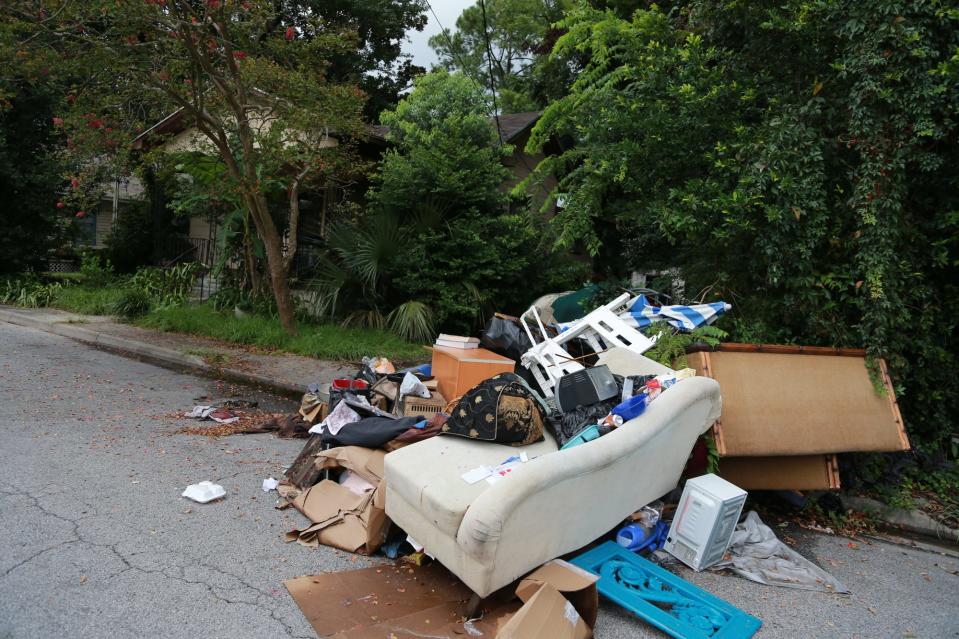 A couch, tv, and other belongings have been discarded at the curb on Helmkin Street.