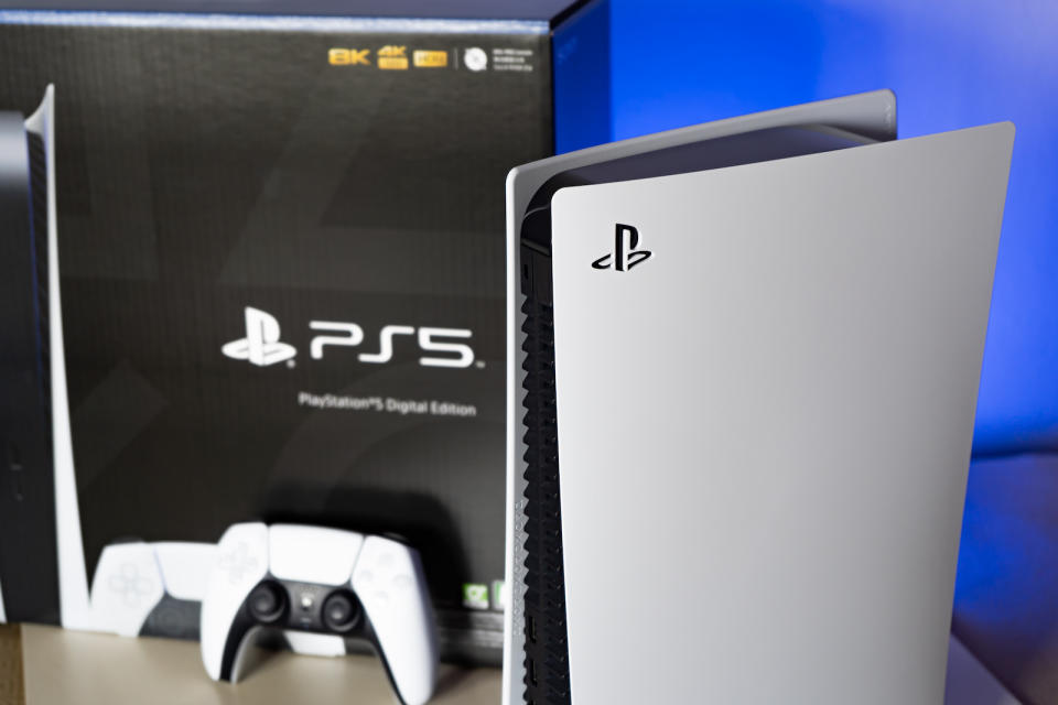A picture of a white Sony PlayStation 5 together with a controller and its packaging.