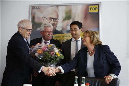 Sabine Leutheusser-Schnarrenberger (R) of the liberal Free Democratic Party (FDP) shakes hands with the FDP top candidate in the upcoming general election, Rainer Bruederle (L) as the party's Bavarian state election top candidate Martin Zeil (2nd L) and FDP party leader, Economy Minister Philipp Roesler, watch before a meeting of party leaders in Berlin, September 16, 2013. REUTERS/Thomas Peter