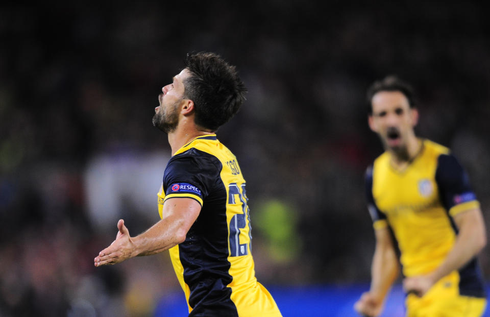 Atletico's Diego, left, celebrates after scoring during a first leg quarterfinal Champions League soccer match between Barcelona and Atletico Madrid at the Camp Nou stadium in Barcelona, Spain, Tuesday April 1, 2014. (AP Photo/Manu Fernandez)