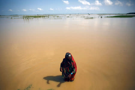 A flood victim washes herself at the flood affected area in Saptari District, Nepal August 14, 2017. REUTERS/Navesh Chitrakar