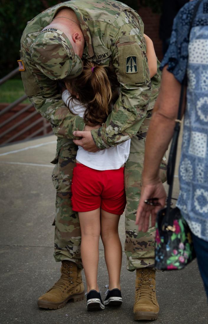 Capt. Matthew Holtman of Brownsburg, Ind., embraces his daughter, Eleanor, 5, at the Indiana National Guard 1st Battalion, 163rd Field Artillery's send-off at the Christian Fellowship Church in Evansville Tuesday evening, Aug. 9, 2022.