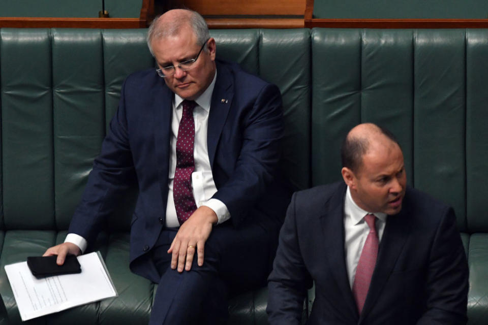 CANBERRA, AUSTRALIA - MARCH 23: Treasurer Josh Frydenberg speaks at the despatch box as Prime Minister Scott Morrison (left) listens to proceedings in the House of Representatives at Parliament House on March 23, 2020 in Canberra, Australia. Parliament is sitting as scheduled but with restrictions in place to limit the number of people in chamber to observe social distancing rules in place due to COVID-19. Prime Minister Scott Morrison announced late on Sunday that from midday Monday, venues such as bars, clubs, nightclubs, cinemas, gyms and restaurants, along with anywhere people remain static would be closed. Schools remain open but parents have the option to keep children at home if they wish while Victoria is bringing forward school holidays from Tuesday. There are now 1353 confirmed cases of COVID-19 In Australia and the death toll now stands at seven. (Photo by Sam Mooy/Getty Images)