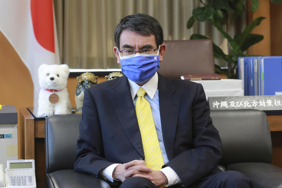 Japanese Vaccine Minister Taro Kono wearing a face mask with Japanese and EU flags on it speaks during an interview in Tokyo, Monday, March 29, 2021. Kono tasked with COVID-19 vaccinations urged the EU to ensure stable shipment of Pfizer vaccines amid distribution uncertainty in a country where the Olympics are coming up in four months. (AP Photo/Koji Sasahara)