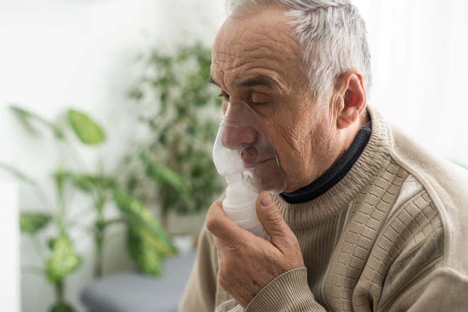 Sick elderly man makes inhalation