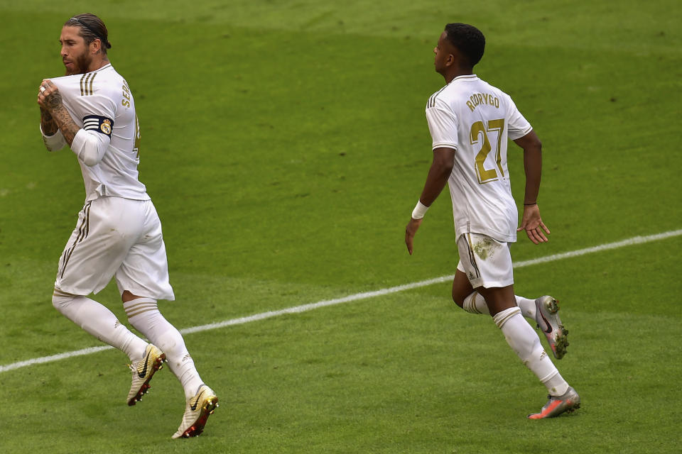 Real Madrid's Sergio Ramos, left, celebrates after scoring the opening goal from a penalty shoot during the Spanish La Liga soccer match between Athletic Club and Real Madrid at the San Manes stadium in Bilbao, Spain, Sunday, July 5, 2020. (AP Photo/Alvaro Barrientos)