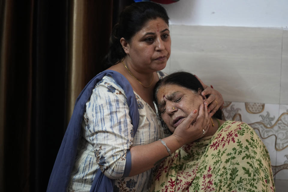 Rattna Pandita is consoled by her daughter Rohini as she mourns for her son Ajay Pandita Bharti, a Kashmiri Hindu village head who was shot dead in Kashmir, at their residence in Jammu, India, June 14, 2022. Kashmir has witnessed a spate of targeted killings in recent months. Several Hindus, including immigrant workers from Indian states, have been killed. (AP Photo/Channi Anand)