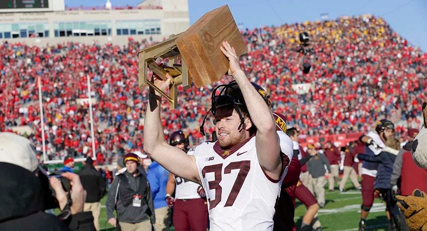 Minnesota punter Peter Mortell (37) carries the Bits of Broken Chair Trophy following an NCAA college football game against Nebraska in Lincoln, Neb., Saturday, Nov. 22, 2014. Minnesota won 28-24.