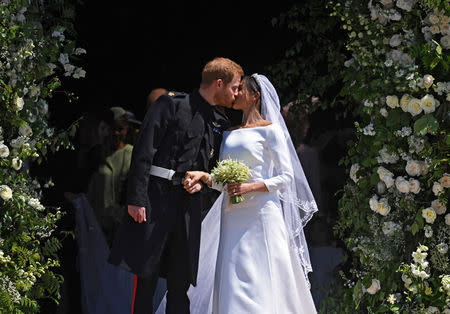 El príncipe Enrique de Inglaterra y Meghan Markle se besan a la salida de la capilla de San Jorge en el Castillo de Windsor, en Londres. 19 de mayo de 2018. NEIL HALL/Pool vía REUTERS