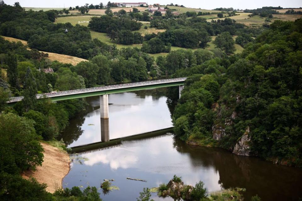 The 2023 Criterium du Dauphine peloton crossing the River Loire late on stage 3