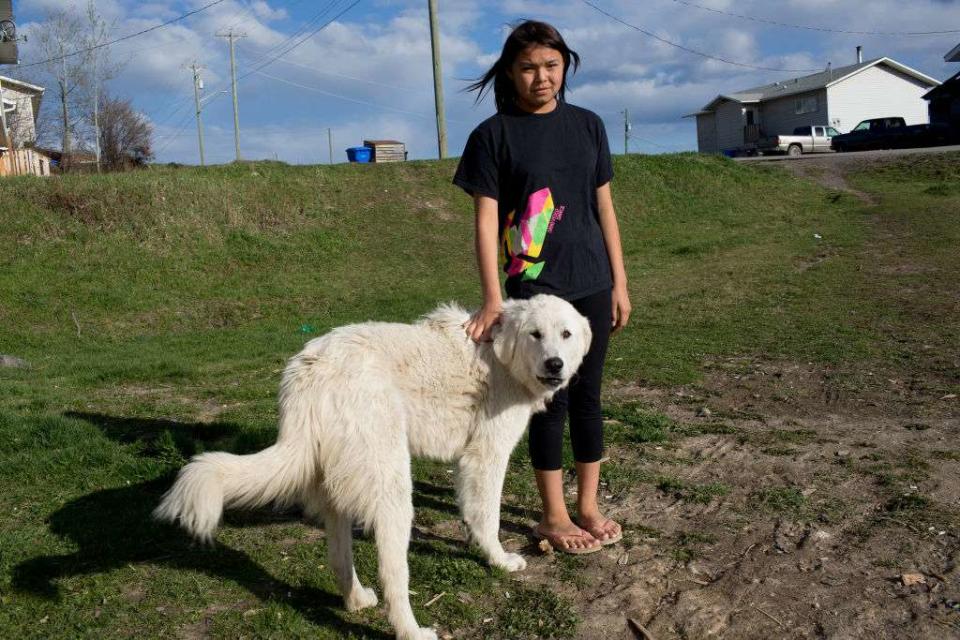 <p>Andrew Lichtenstein/Corbis News via Getty Images</p>  A Young First Nation walks down a street with her protective dog on April 25, 2016 in the small community of Taiche, British Columbia. Three years after 26 year old Mackie Basil disappeared after last being seen on a remote logging road outside of the First Nation village of Taiche, her family still organizes search parties in the vast, remote wilderness.