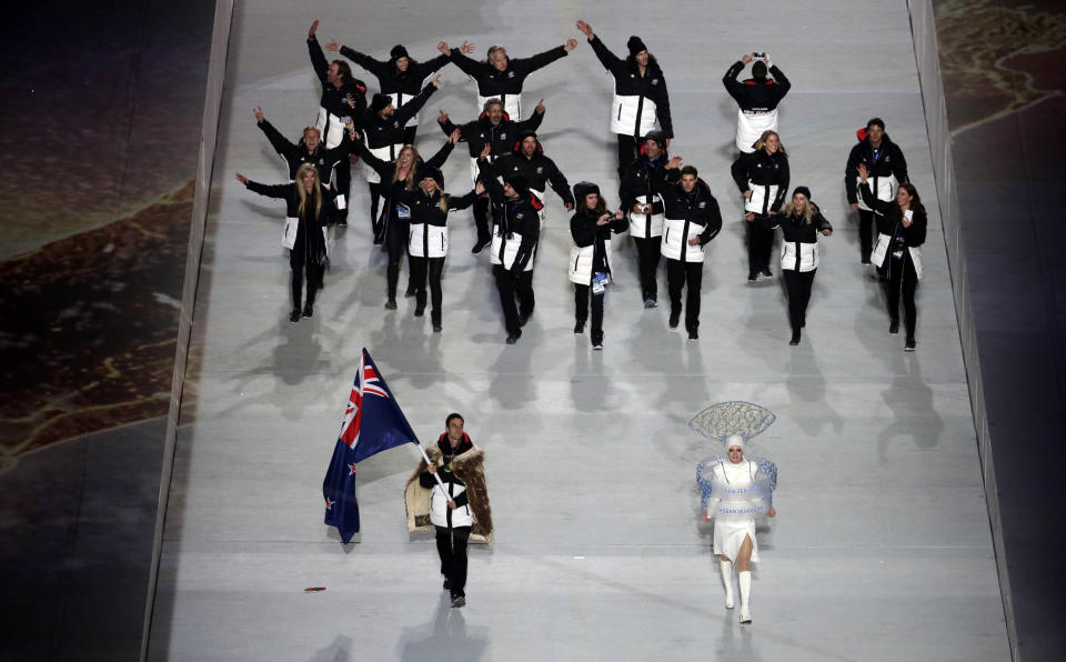 Shane Dobbin of New Zealand holds his national flag and enters the arena with teammates during the opening ceremony of the 2014 Winter Olympics in Sochi, Russia, Friday, Feb. 7, 2014. (AP Photo/Charlie Riedel)