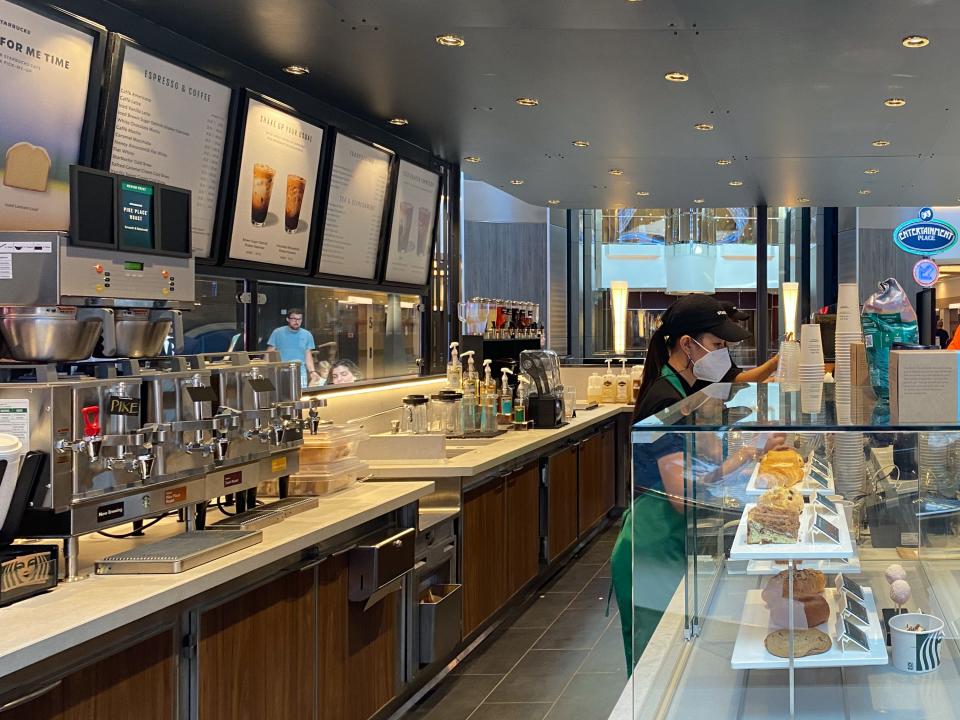 A starbucks stand on an indoor deck on a cruise ship