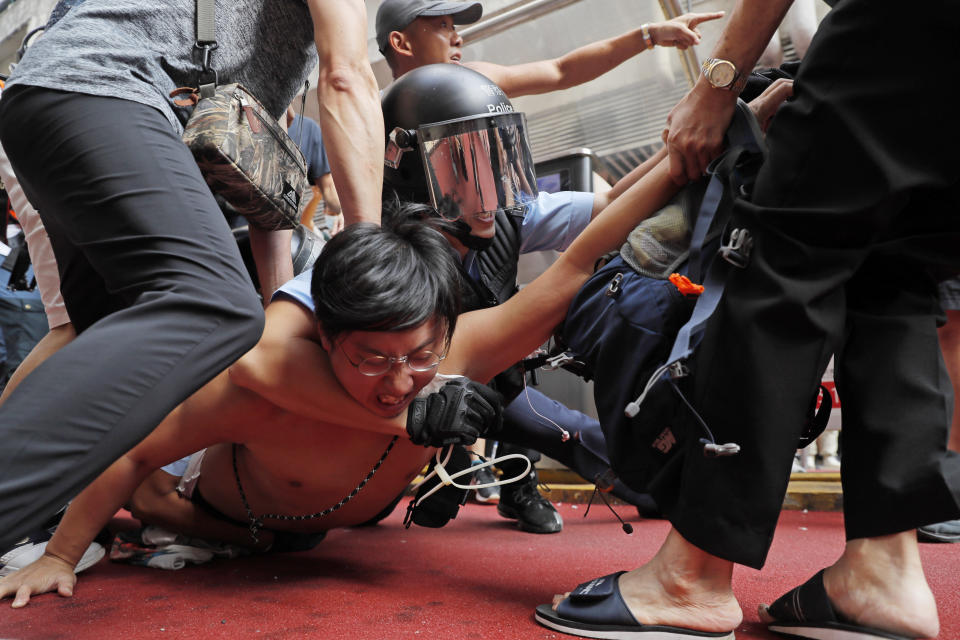 FILE - Police detain a man after fights broke out between pro-China supporters and anti-government protesters outside the Amoy Plaza in the Kowloon Bay district in Hong Kong, Saturday, Sept. 14, 2019. As Beijing prepares to hold the Winter Olympics next month, party leader and President Xi Jinping is more intent than ever on realizing his vision of a China that is authoritarian, economically powerful and destined to dominate its region and beyond, with political stability at home paramount. (AP Photo/Kin Cheung, File)