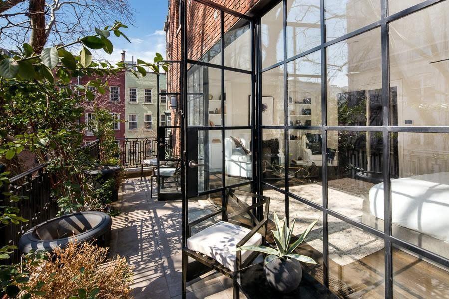 <br>French doors within a full wall of windows open up access to the garden.