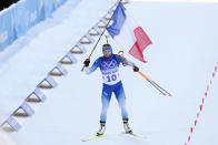 Justine Braisaz-Bouchet of France crosses the finish line during the women's 12.5-kilometer mass start biathlon at the 2022 Winter Olympics, Friday, Feb. 18, 2022, in Zhangjiakou, China. (AP Photo/Kirsty Wigglesworth)