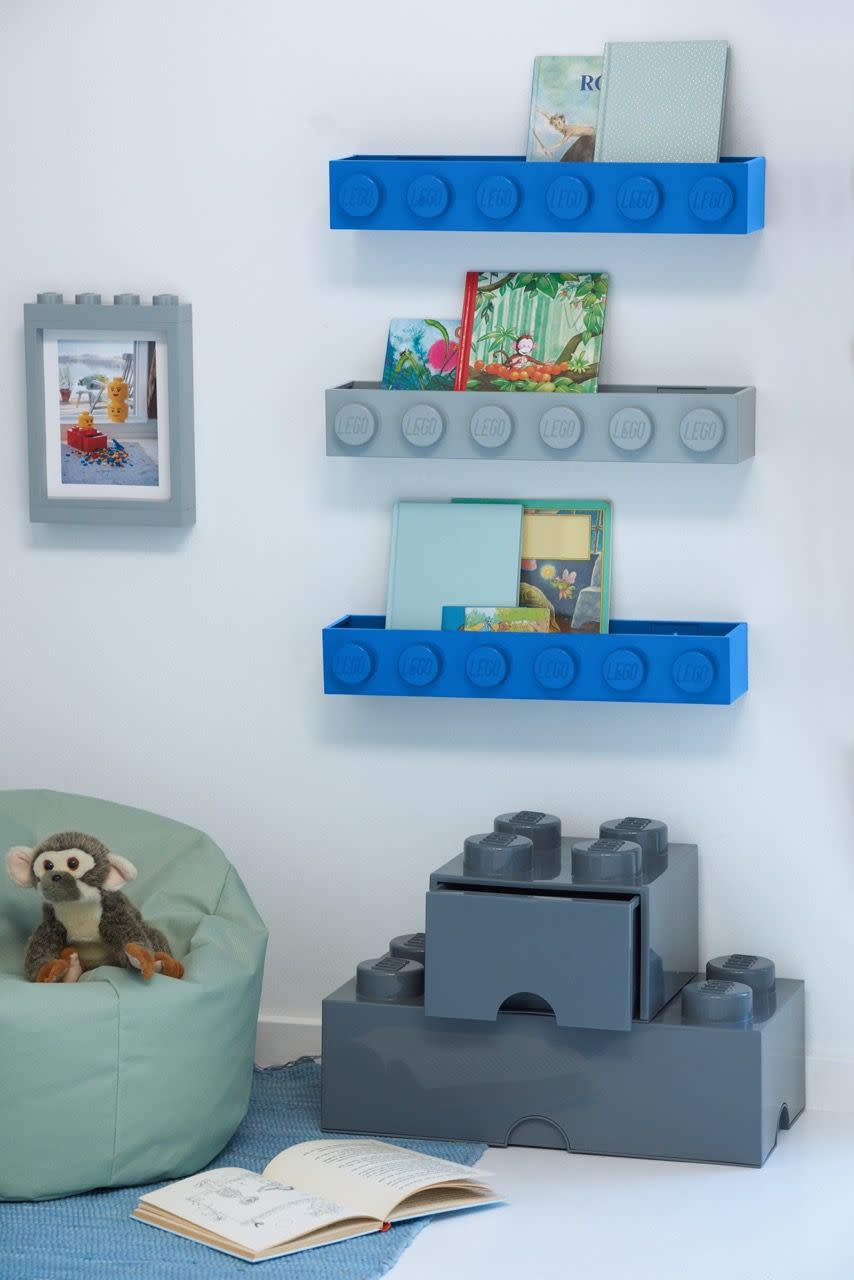 a room with a shelf with pictures and a stuffed animal