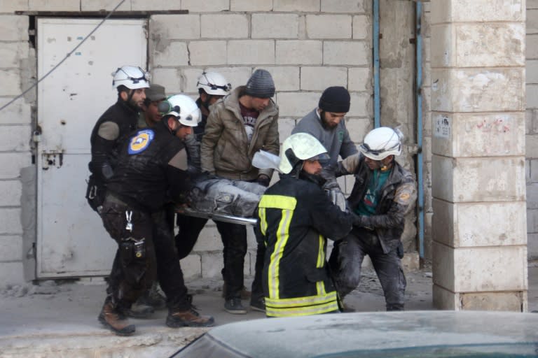 Syrian civil defence volunteers, known as the White Helmets, carry a comrade who was injured in an air strike in the rebel-held town of Binnish, on the outskirts of Idlib, on February 25, 2017