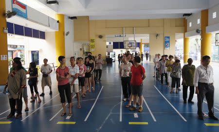 Voters queue to cast their ballots during the general election at a polling center in Singapore September 11, 2015. REUTERS/Edgar Su