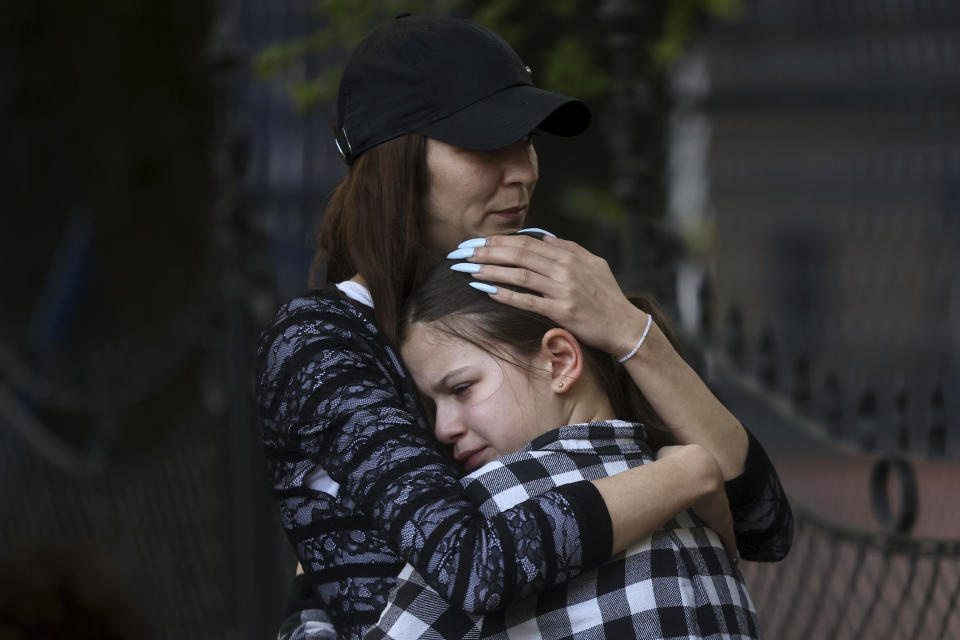 FILE - A woman hugs a girl near the Vladislav Ribnikar school in Belgrade, Serbia, Wednesday, May 3, 2023. A teenage boy opened fire at the school on the morning of May 3, 2023. Eight children and a school guard died, and seven people were wounded. One of the wounded, a child, died from injuries later. A total of 10 people were killed. (AP Photo/Armin Durgut, File)