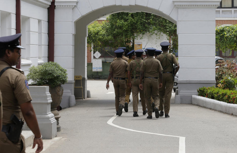 Sri Lankan police officers arrive at a public school to conduct a search in Colombo, Sri Lanka, Sunday, May 5, 2019. Sri Lankan Catholics celebrated Sunday Mass in their homes for a second week as churches remain closed amid fears of possible fresh attacks by Islamic extremists. (AP Photo/Eranga Jayawardena)