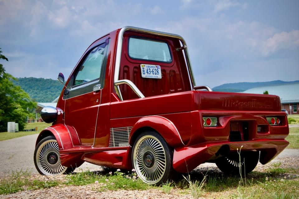 A red 1996 Daihatsu Midget II, seen from the rear three-quarter angle