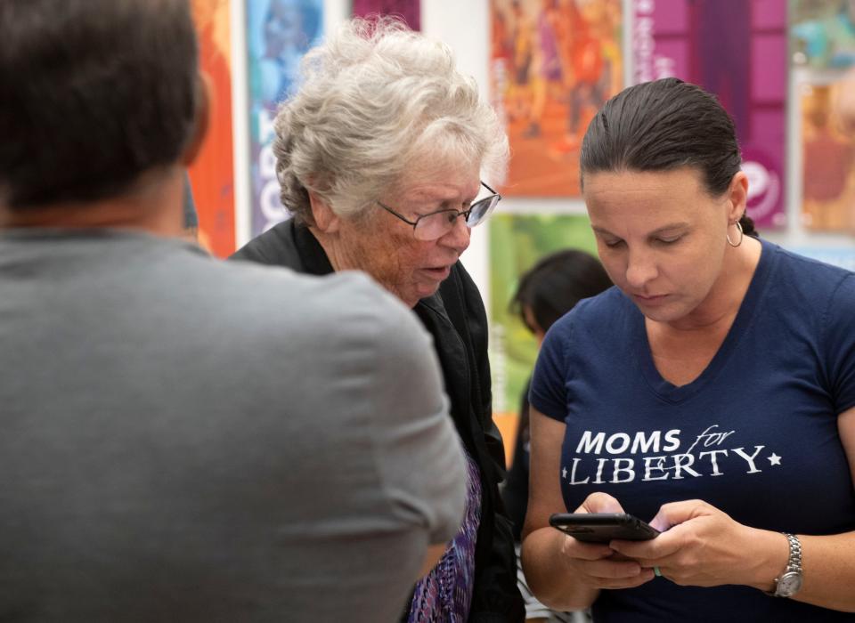 Jennifer Pippin (right), who heads the Indian River County chapter of Moms For Liberty, talks with retired New York City teacher Mickey Schaff during a school board meeting where members of the nonprofit were fighting for the removal of books in school libraries they deem to be pornographic or sexually explicit Tuesday, Nov. 16, 2021, at the School District of Indian River County. "I'm really with them" Schaff said. 