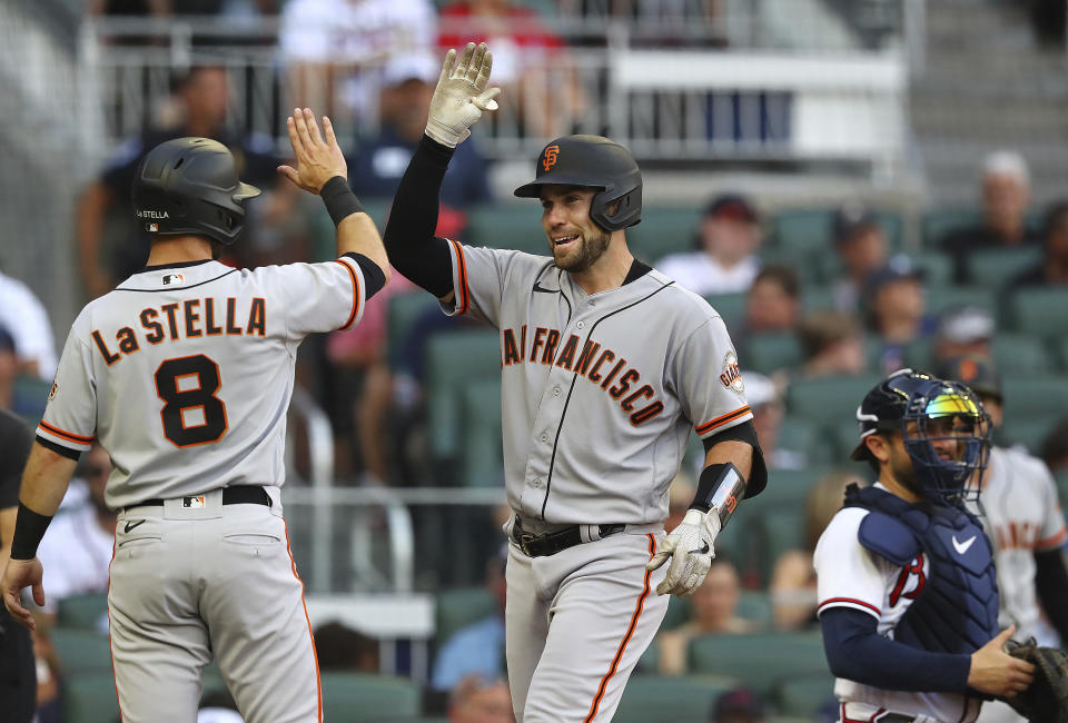 San Francisco Giants catcher Austin Wynns (right) gets a fiver from Tommy La Stella after hitting a 3-run homer against Braves starting pitcher Spencer Strider to take a 4-0 lead during the second inning of a baseball game on Tuesday, June 21, 2022, in Atlanta. (Curtis Compton Atlanta Journal-Constitution via AP)