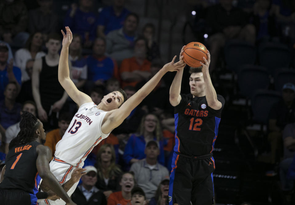 Auburn forward Walker Kessler (13) tries to block Florida forward Colin Castleton (12) during the first half of an NCAA college basketball game against Florida Saturday, Feb. 19, 2022, in Gainesville, Fla. (AP Photo/Alan Youngblood)