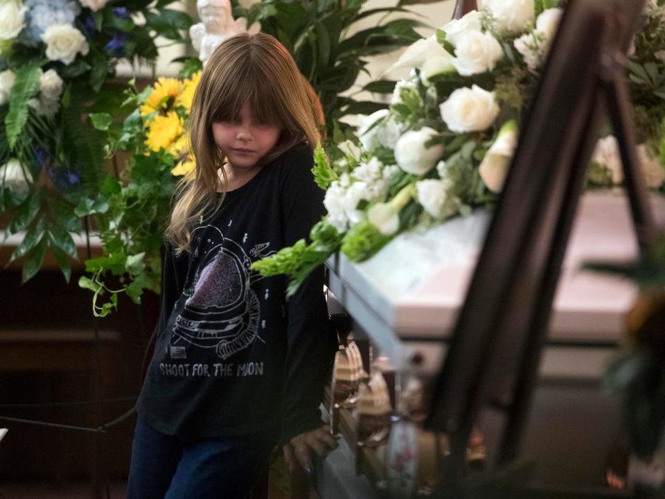 Natalie Brown stands near her older sister, Angelina "Gia" Givens' casket during her services at Berry Lynnhurst Funeral Home on Monday, October 22, 2018. The 16-year-old, former Gibbs High School student committed suicide on the school grounds on October 18. 