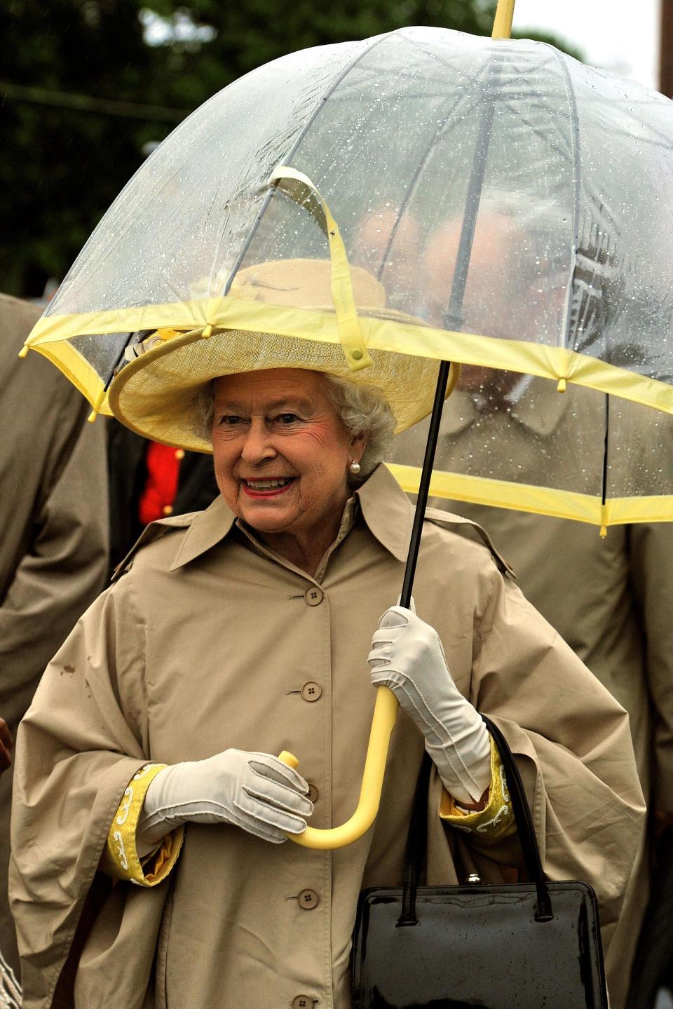 <p>Both the sleeves of the Queen's dress and her hat match the yellow on this umbrella.</p>