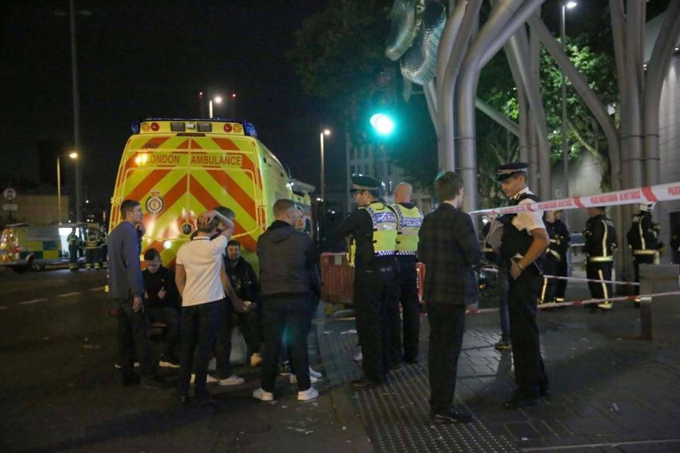 Police at the scene of the attack in east London (PA)