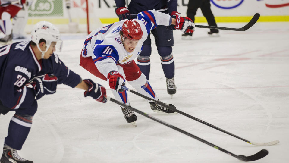 Russia's Bogdan Yakimov, center, fights for the puck with Connor Carrick of the USA during their World Junior Hockey Championships quarter final in Malmo, Sweden on Thursday, Jan. 2, 2014. (AP Photo/Andreas Hillergren) ** SWEDEN OUT **