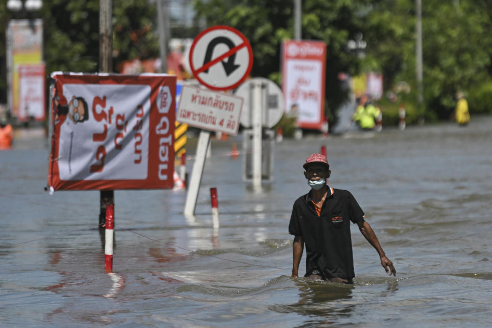 A resident wades through floodwaters, Wednesday, Oct. 5, 2022, in Ubon Ratchathani province, northeastern Thailand. Authorities in Thailand are warning of possible serious floods in Bangkok and central areas, ahead of expected heavy seasonal rainfall through the rest of the week. The situation is being worsened by a large volume of water moving down from flooding in the north of the country and from discharges from brimful dams. (AP Photo/Sukanya Buontha)
