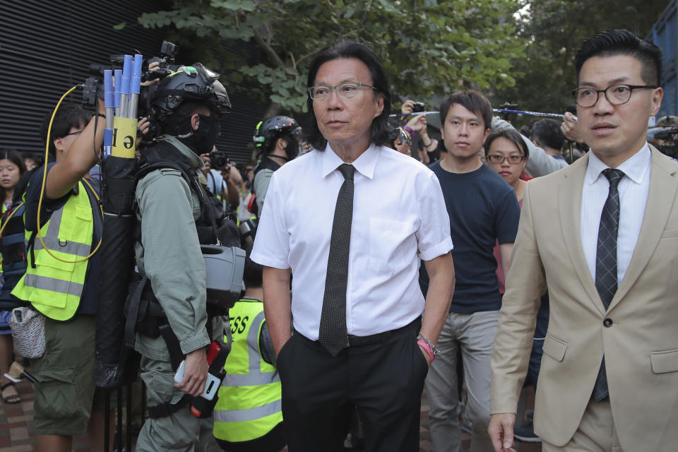 In this Monday, Nov. 25, 2019 photo, lawyer Daniel Wong Kwok-tung, center, arrives at the Polytechnic University to meet the protesters in Hong Kong. Hong Kong national security police on Thursday, Jan. 14, 2021, arrested a lawyer and 10 others on suspicion of helping 12 Hong Kongers try to flee the city, local media reported in the latest arrests in an ongoing crackdown on dissent. Wong, a member of the city's Democratic Party, is known for providing legal assistance to hundreds of protesters arrested during the anti-government protests in Hong Kong in 2019. (AP Photo/Kin Cheung)