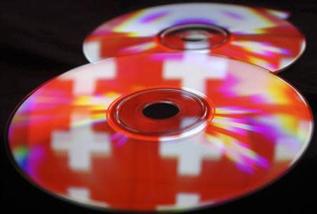 Compact discs with images of the Swiss flag are seen in this photo illustration taken in the central Bosnian town of Zenica, May 3, 2013. REUTERS/Dado Ruvic