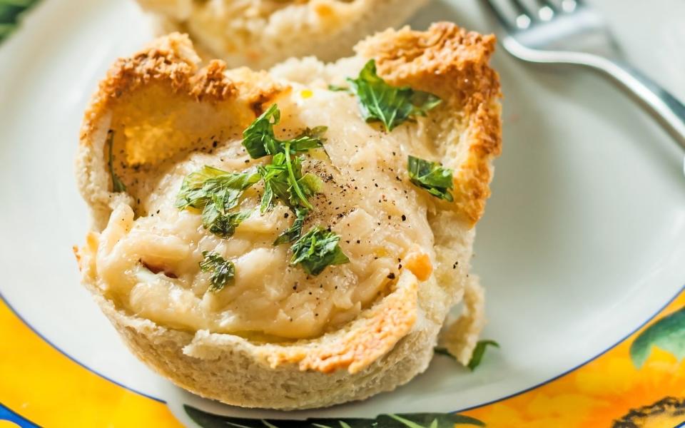 Als besonderes Frühstück oder als Teil einer Brunch-Tafel bieten sich "Eier im Nest" an. Für dieses Toast-Rezept werden Toastscheiben (am besten ohne Rand) mit Butter bestrichen und jeweils in eine Mulde einer Muffinform gepresst. Je nach Geschmack können Sie Speck, Tomaten, Petersilie und Eier als Füllung wählen. Die Nester werden bei 180 Grad im Ofen gebacken. (Bild: iStock/~UserGI15633745)