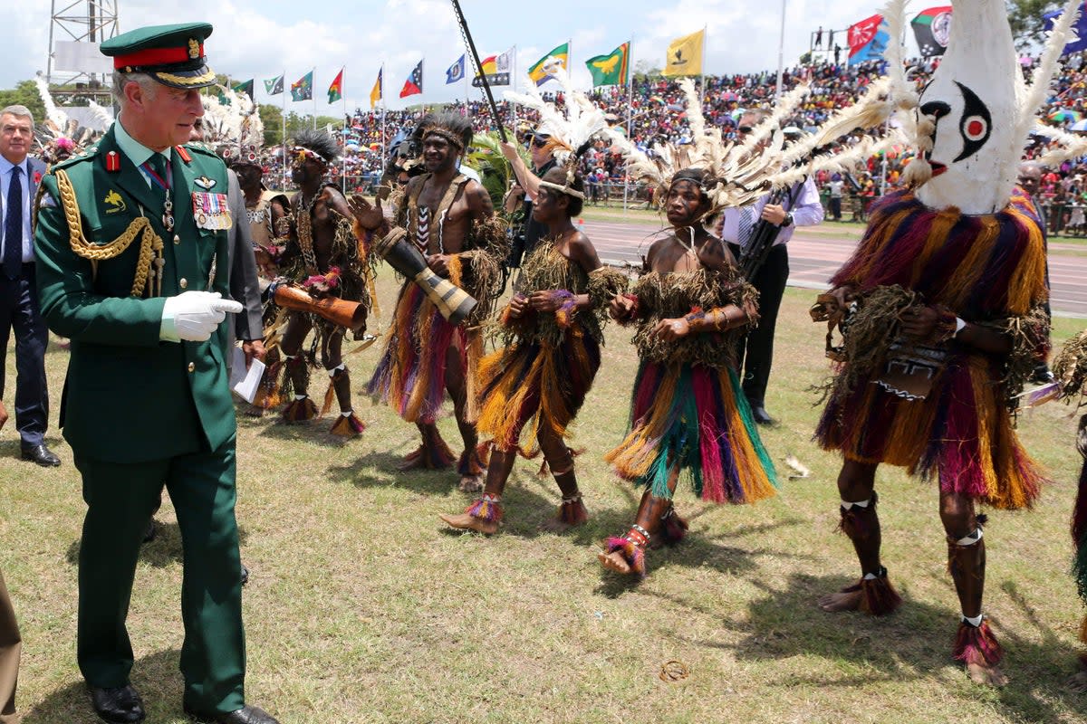 The then Prince of Wales meets dancers dressed in traditional dress during a visit to the Sir John Guise Stadium in Papua New Guinea in 2012 (Chris Radburn/PA) (PA Archive)