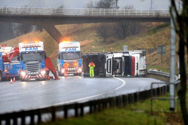 Recovery workers prepare to recover an overturned lorry at the scene of an accident on the eastbound track of the M62 motorway between junctions 21 (Milnrow) and 22 (Ripponden) (Danny Lawson/PA)