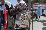 A woman holds a poster with a picture of a Palestinian prisoner that reads "the prisoner hero Issa Jabbareen, I starve for your dignity and pride" during a protest supporting prisoners, in the West Bank city of Ramallah, Tuesday, Sept. 14, 2021. Hundreds of thousands of Palestinians have passed through a military justice system designed for a temporary occupation that is now well into its sixth decade. Nearly every Palestinian has a loved one who has been locked up in that system at some point, and imprisonment is widely seen as one of the most painful aspects of life under Israeli rule. (AP Photo/Nasser Nasser)